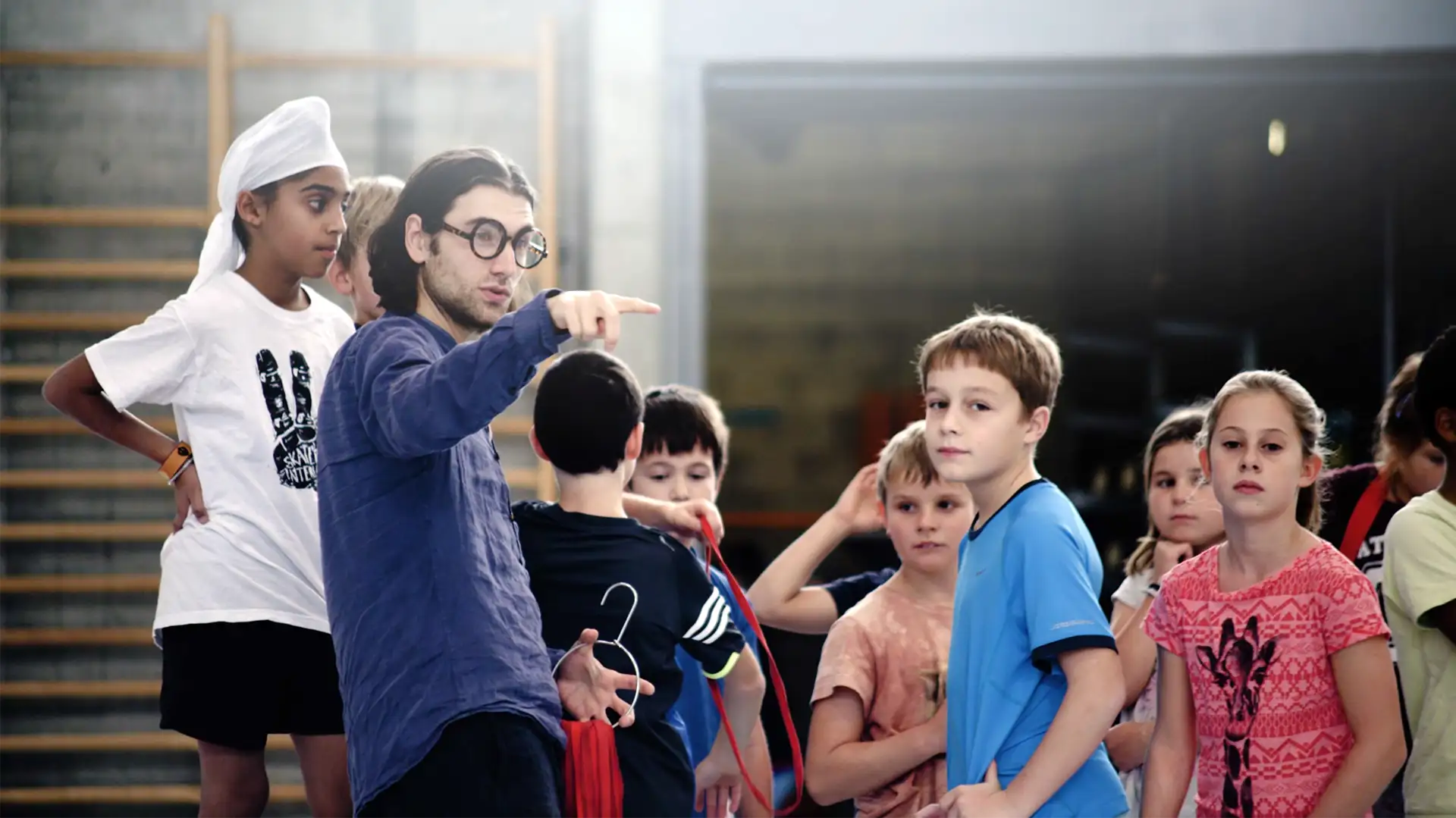 Student der Akademie für anthroposophische Pädagogik leitet eine Sportstunde, SchülerInnen im Hintergrund