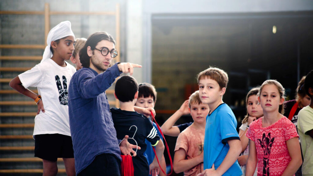 Student der Akademie für anthroposophische Pädagogik leitet eine Sportstunde, SchülerInnen im Hintergrund